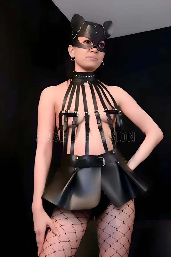 Black faux leather strappy cage body harness with flared mini skirt and cat ear mask, full set on model