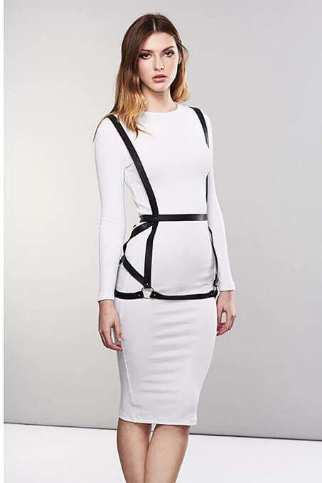 black faux leather body harness with silver O-ring waist belt worn over white fitted dress, front view