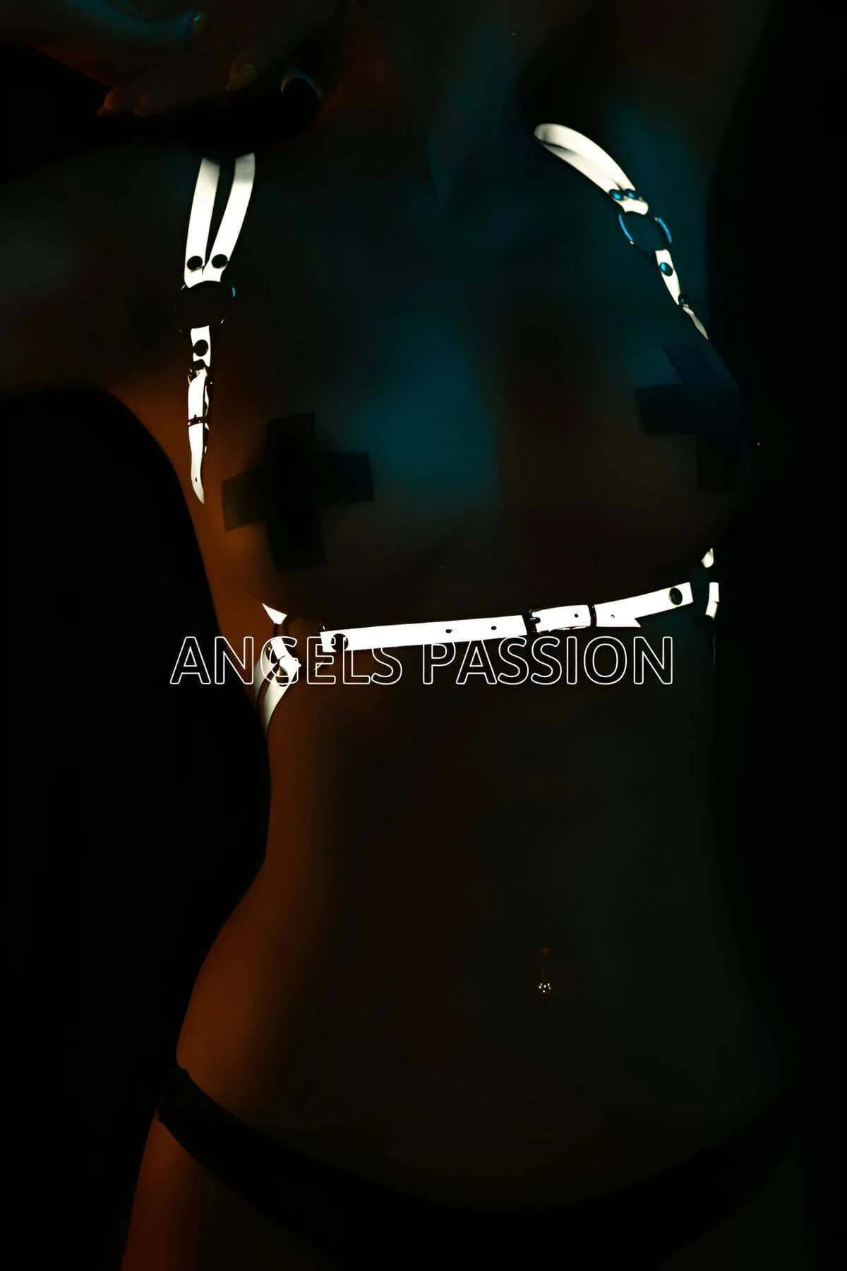Reflective body harness top white glowing straps on dark background club lighting festival accessory adjustable