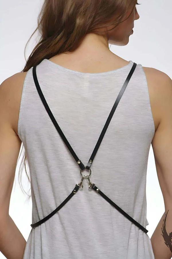 Black faux leather X-back body harness with silver O-ring, worn over gray tank top, back view
