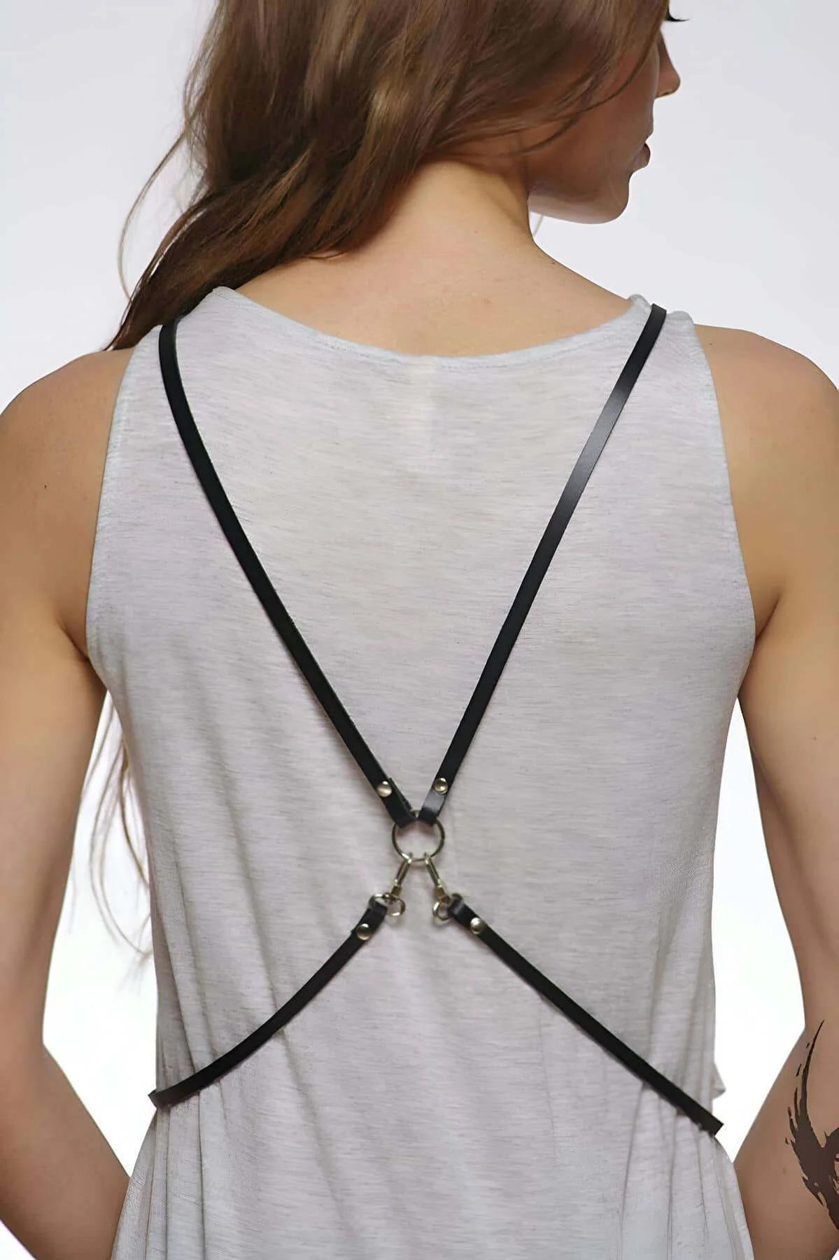 Black faux leather X-back body harness with silver O-ring, worn over gray tank top, back view