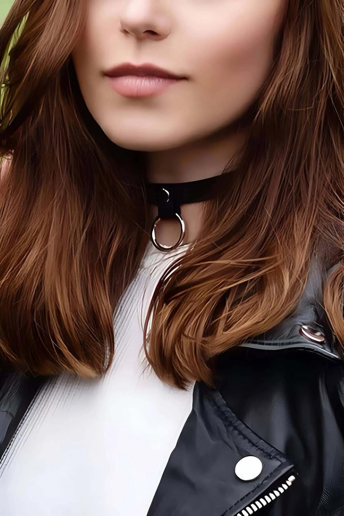 Black faux leather O-ring choker necklace with silver-tone ring worn at throat base over white ribbed top