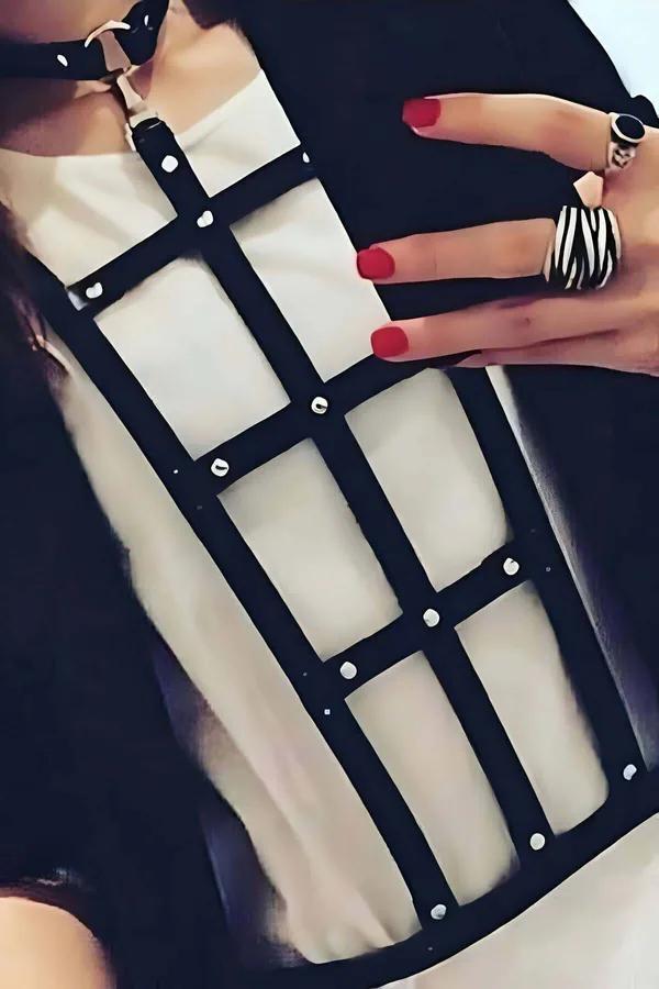 Black faux leather grid chest harness with silver stud rivets at intersections, worn over a white T-shirt