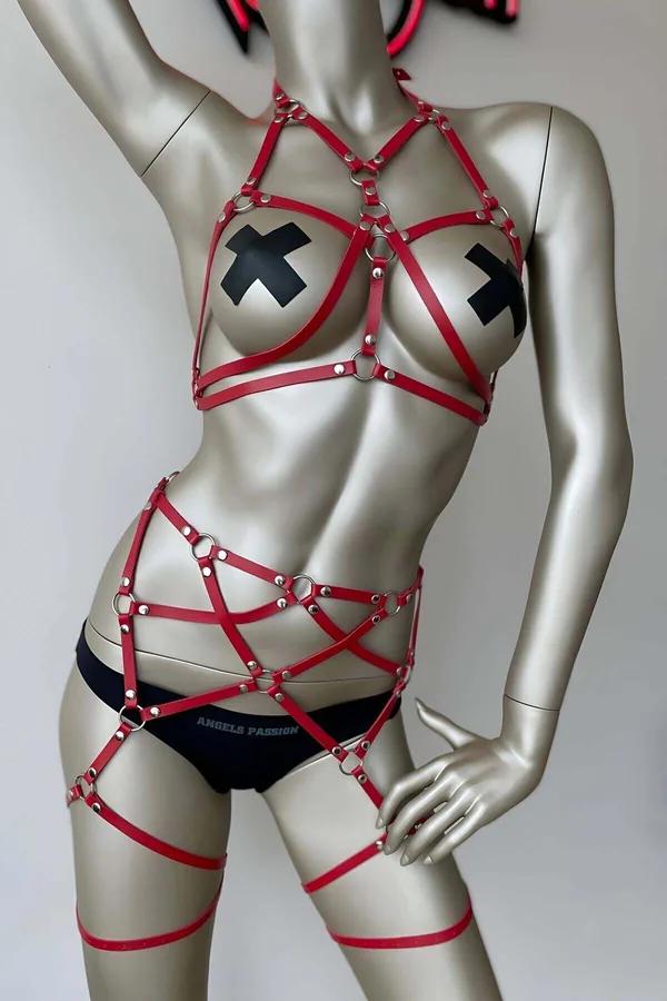 Red faux leather strappy body harness with silver O-rings, geometric chest cage, waist straps, and integrated thigh garter ba