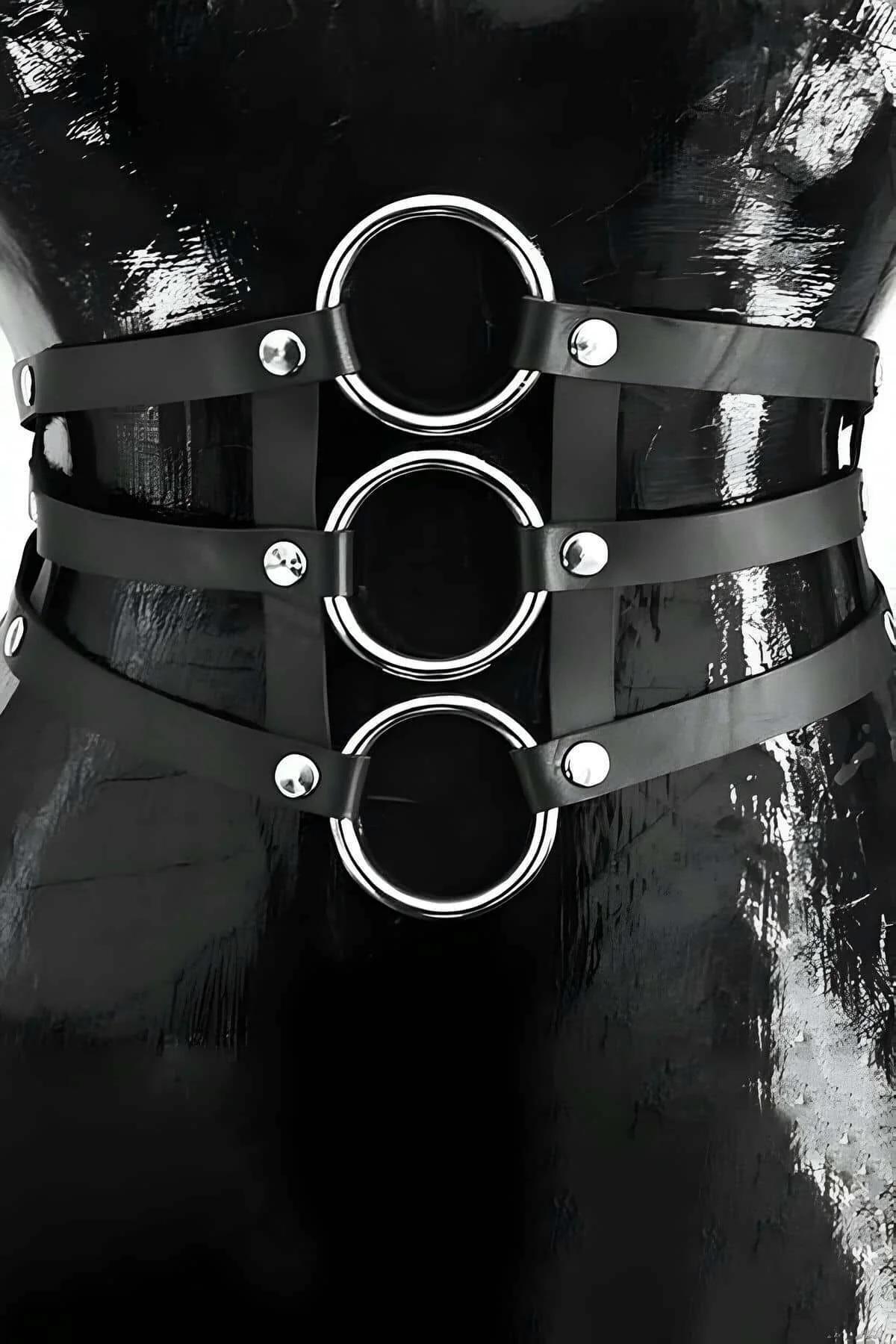 black faux leather waist harness with three stacked silver O-rings and dome rivets on female torso