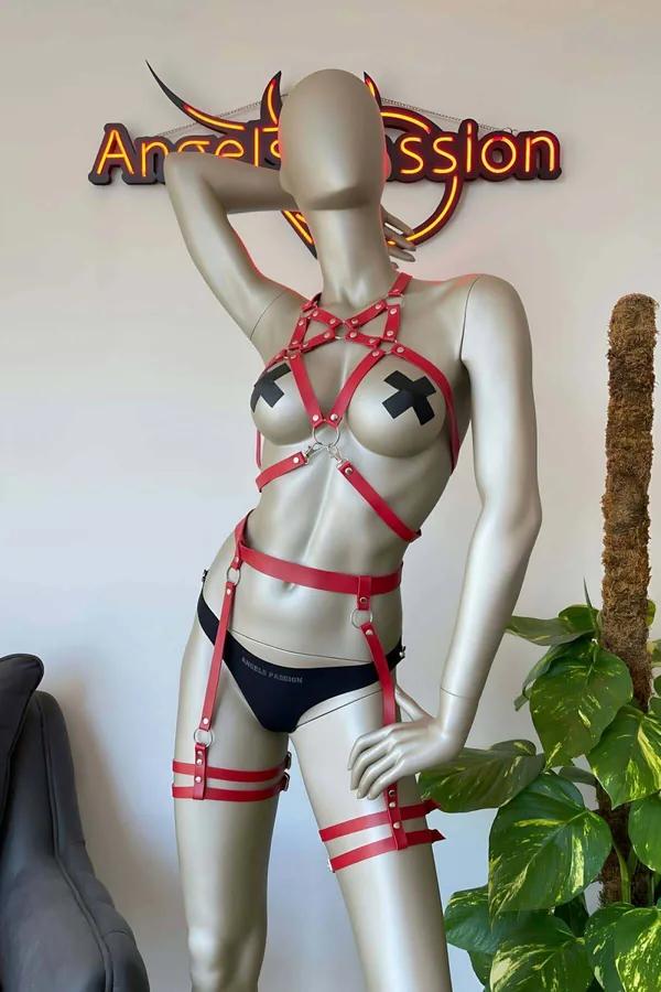 Red faux leather full body harness with star chest detail, silver O-rings, double thigh straps, and calf bands on mannequin
