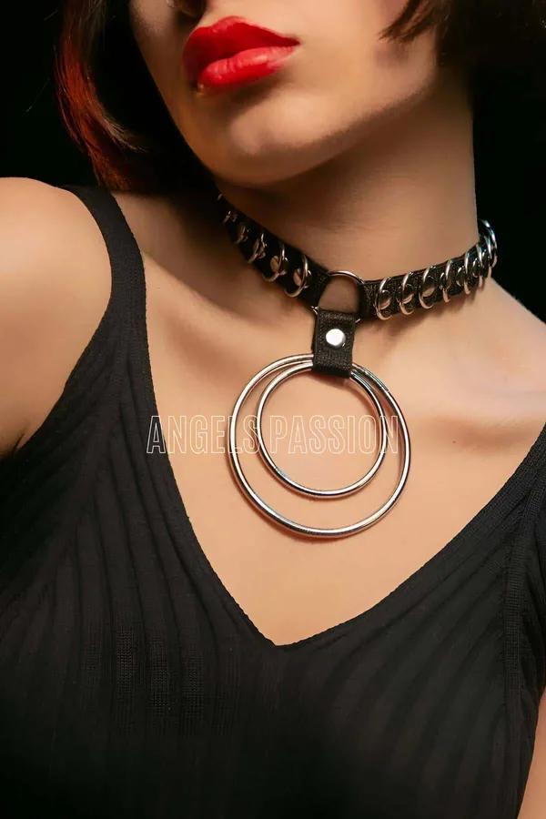Black faux leather choker with interwoven silver chain band and two concentric silver O-ring pendants at neckline