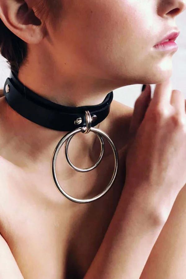Black faux leather choker necklace with double concentric silver O-ring pendant worn at throat