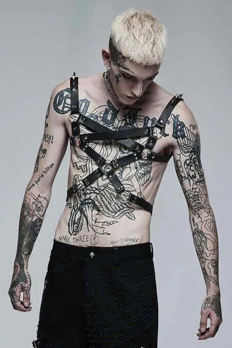 black faux leather mens chest harness with crossing X-pattern straps and silver stud rivets worn over bare skin