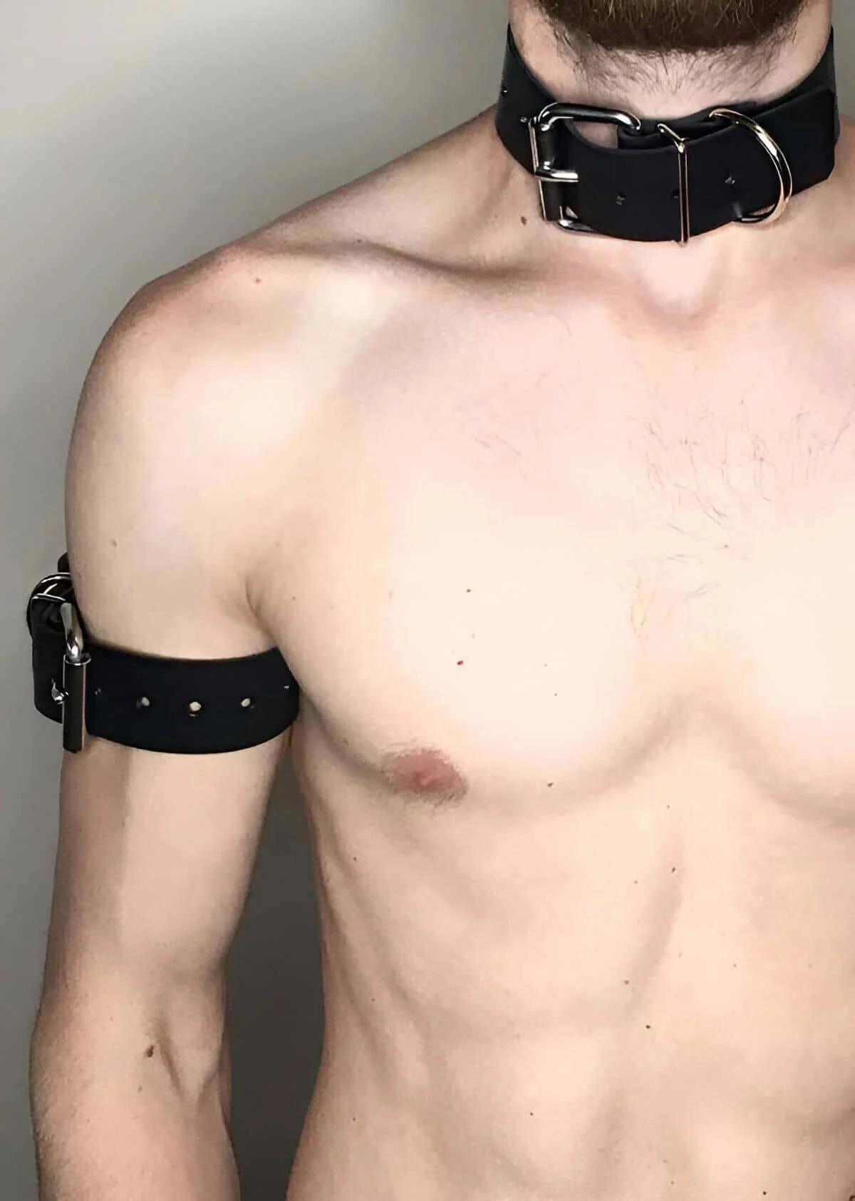 black faux leather wide collar and armband set with silver-tone buckles and D-rings on male model