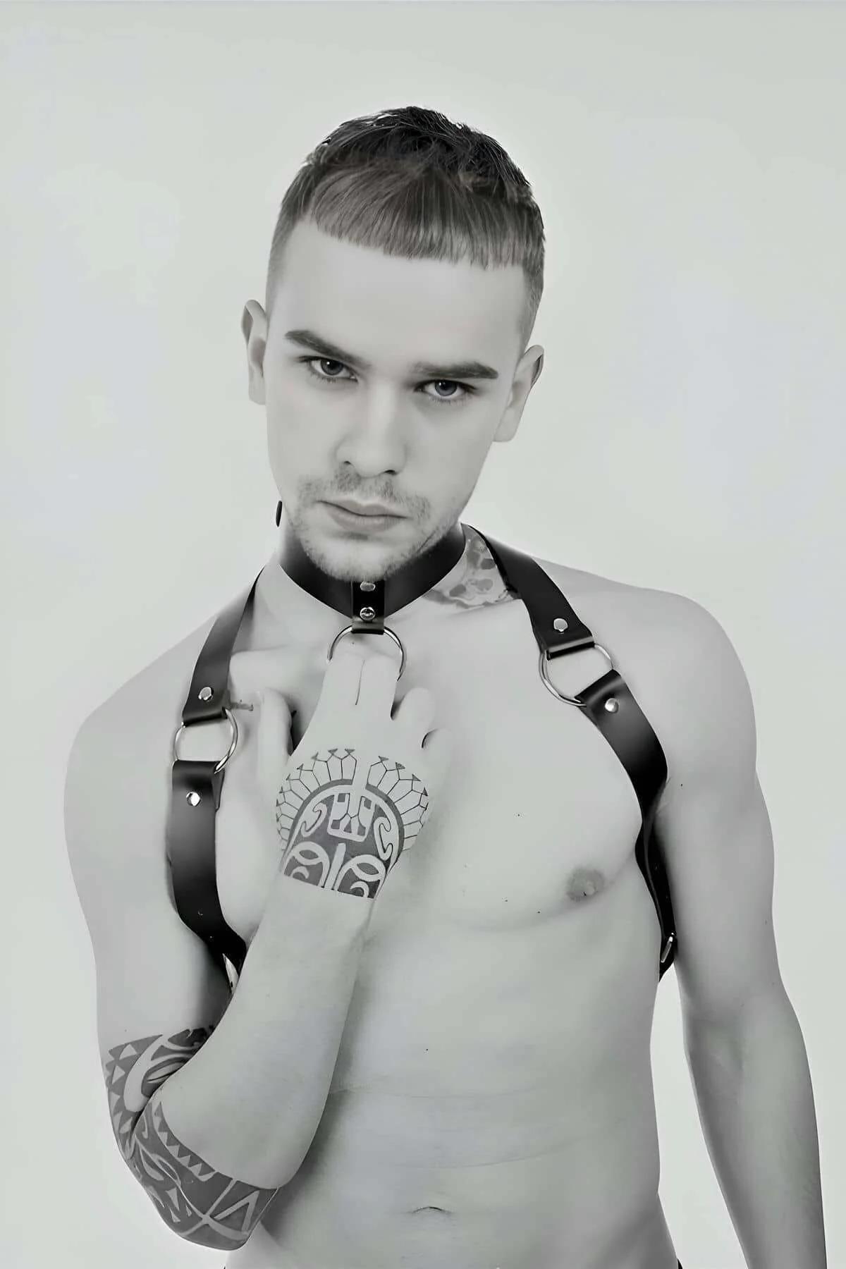 Black faux leather chest harness with silver O-ring and collar strap on male model, diagonal shoulder straps and snap closure