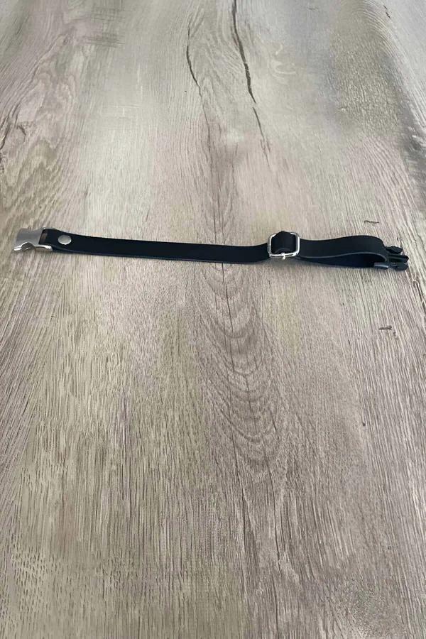 black faux leather collar with silver rectangular buckle and metal clip hardware laid flat on wood surface